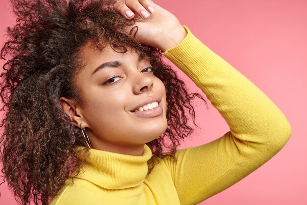 Hermosa mujer vestida con aretes y suéter amarillo