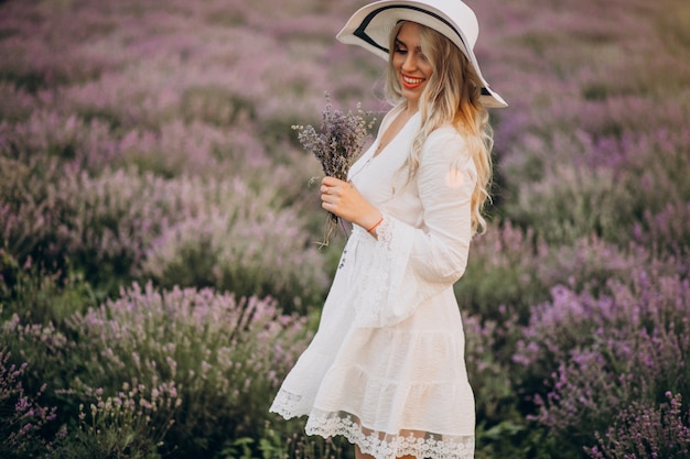 Hermosa mujer vestida de blanco en un campo de lavanda