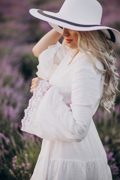 Hermosa mujer vestida de blanco en un campo de lavanda