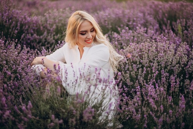 Hermosa mujer vestida de blanco en un campo de lavanda