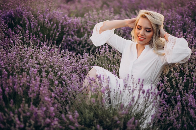 Hermosa mujer vestida de blanco en un campo de lavanda