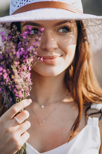 Hermosa mujer vestida de blanco en un campo de lavanda