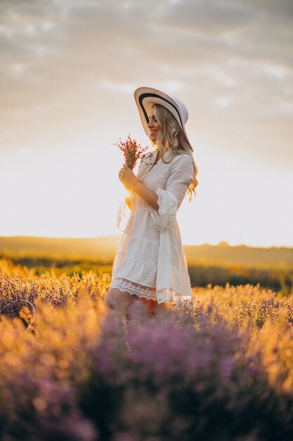 Hermosa mujer vestida de blanco en un campo de lavanda