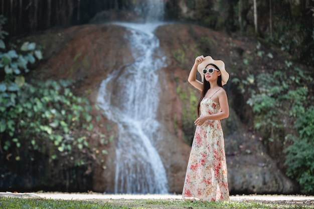 Hermosa mujer vestida junto a la cascada