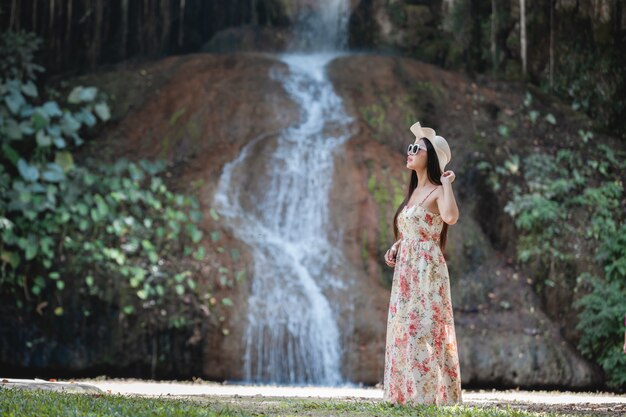 Hermosa mujer vestida junto a la cascada