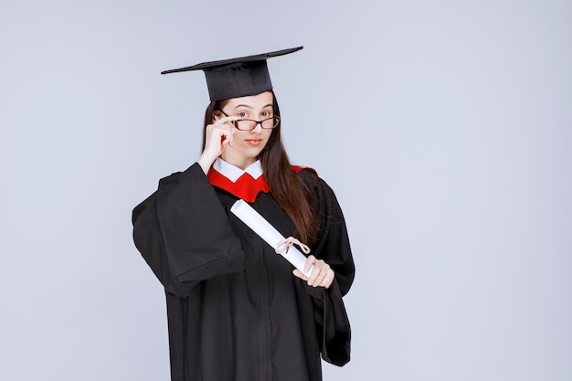 Hermosa mujer en vestido con diploma de graduación de la universidad. Foto de alta calidad