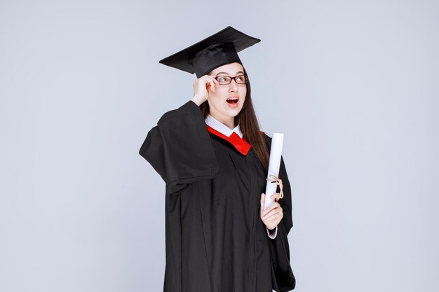 Hermosa mujer en vestido con diploma de graduación de la universidad. Foto de alta calidad