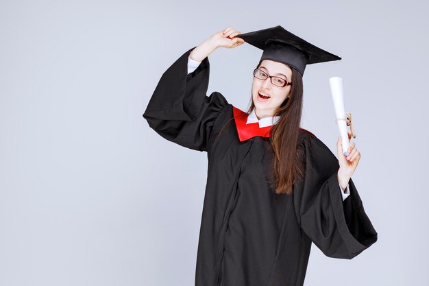 Hermosa mujer en vestido con diploma de graduación de la universidad. Foto de alta calidad