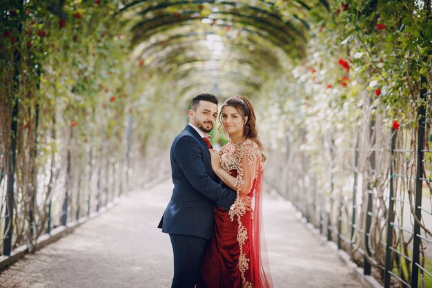 Hermosa mujer en un vestido largo rojo camina por la ciudad con su marido