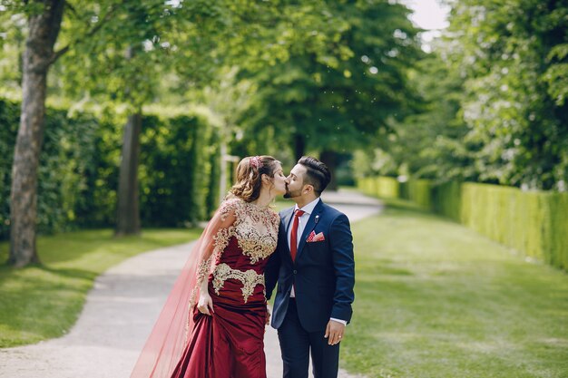 Hermosa mujer en un vestido largo rojo camina por la ciudad con su marido