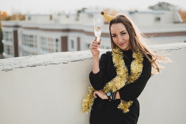 Hermosa mujer en vestido negro con una copa de champán