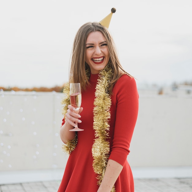 Hermosa mujer en vestido rojo divirtiéndose en una fiesta