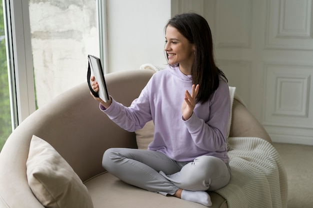 Foto gratuita hermosa mujer con una videollamada en casa