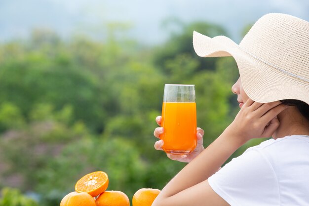 Hermosa mujer vistiendo una camiseta blanca con un vaso de jugo de naranja