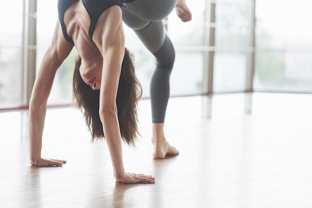 Una hermosa mujer de yoga practicando en un amplio y luminoso gimnasio.