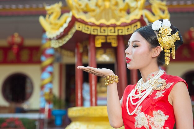 Una hermosa niña asiática vestida con un traje rojo