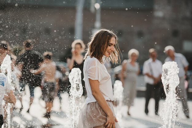 La hermosa niña caminando cerca de la fuente