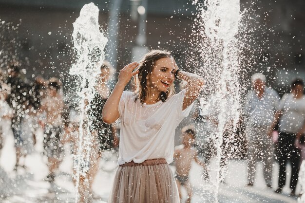 La hermosa niña caminando cerca de la fuente