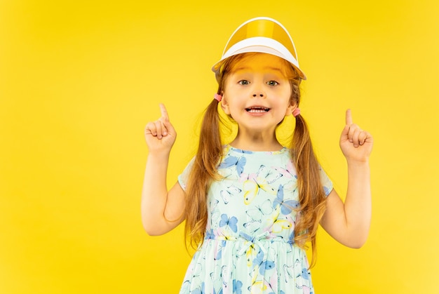 Hermosa niña emocional aislada en amarillo