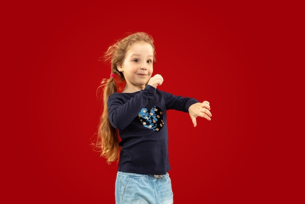 Hermosa niña emocional en estudio rojo