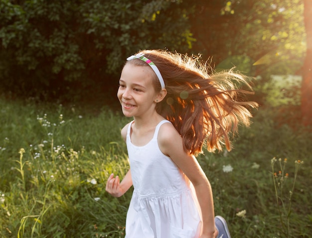 Foto gratuita hermosa niña feliz divirtiéndose en la naturaleza