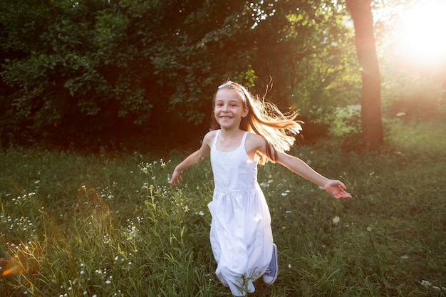 Foto gratuita hermosa niña feliz divirtiéndose en la naturaleza