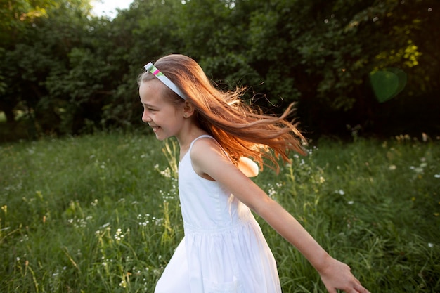 Foto gratuita hermosa niña feliz divirtiéndose en la naturaleza