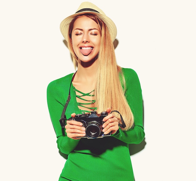 hermosa niña feliz linda mujer rubia en ropa casual verano verde hipster toma fotos con cámara fotográfica retro