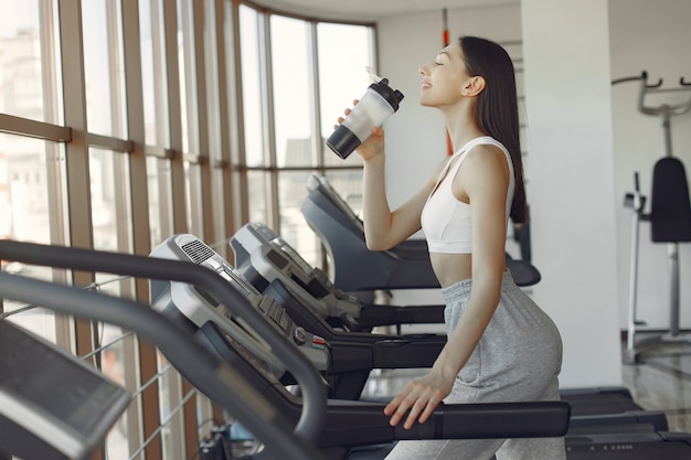 Una hermosa niña en un gimnasio en una pista de carreras