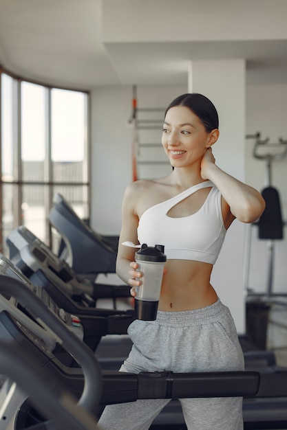 Una hermosa niña en un gimnasio en una pista de carreras