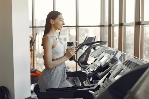 Una hermosa niña en un gimnasio en una pista de carreras