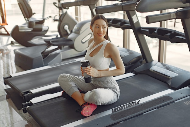 Una hermosa niña en un gimnasio en una pista de carreras