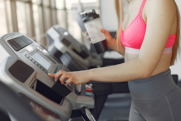 Foto gratuita una hermosa niña en un gimnasio en una pista de carreras