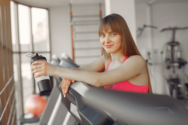 Una hermosa niña en un gimnasio en una pista de carreras