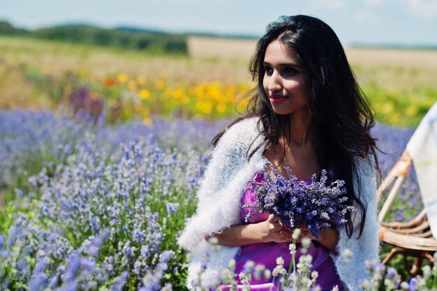 Hermosa niña india usa vestido tradicional saree india en campo de lavanda púrpura