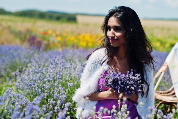 Hermosa niña india usa vestido tradicional saree india en campo de lavanda púrpura