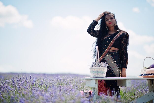 Hermosa niña india usa vestido tradicional saree india en campo de lavanda púrpura