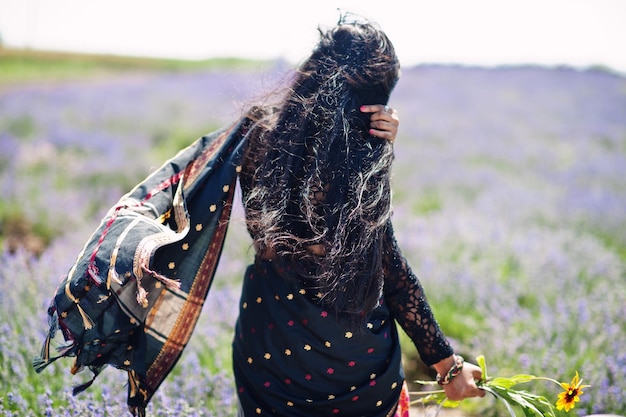 Hermosa niña india usa vestido tradicional saree india en campo de lavanda púrpura