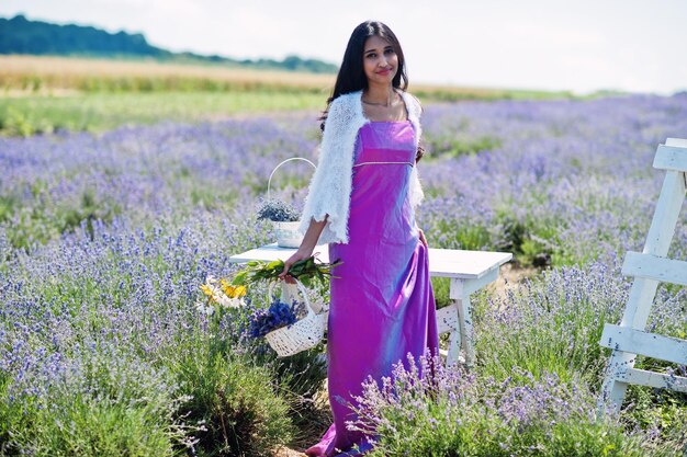 Hermosa niña india usa vestido tradicional saree india en campo de lavanda púrpura