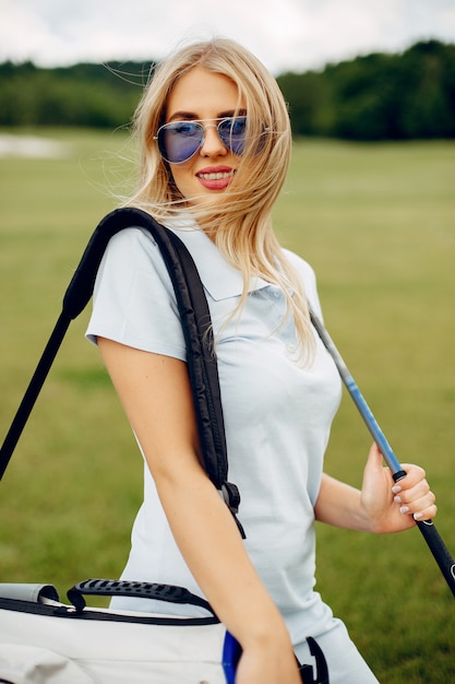 Foto gratuita hermosa niña jugando al golf en un campo de golf