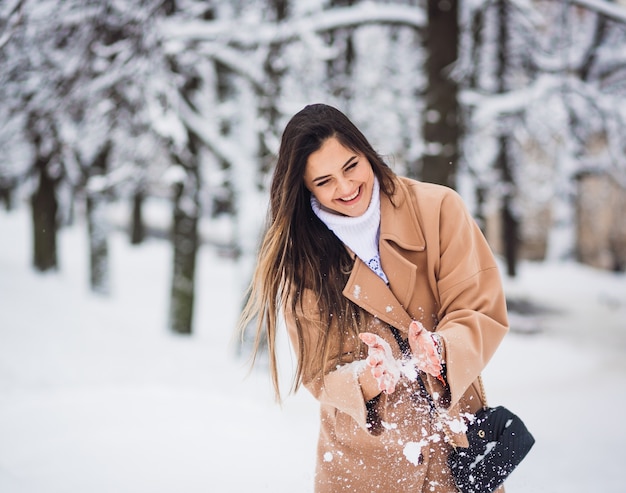 Foto gratuita la hermosa niña jugando con nieve