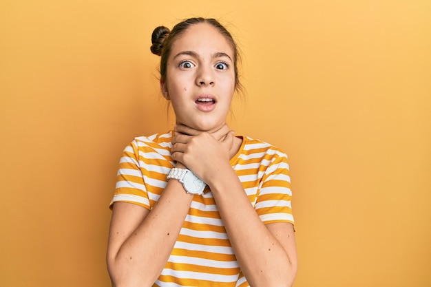 Foto gratuita hermosa niña morena con camiseta casual a rayas gritando sofocada porque el doloroso problema de salud de la estrangulación asfixia y el concepto de suicidio