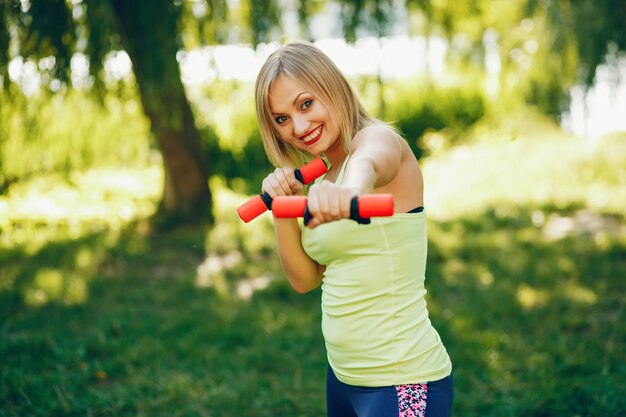 Una hermosa niña participa en el ejercicio de la mañana en el parque.