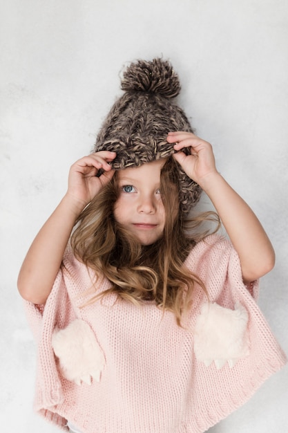 Hermosa niña posando con sombrero de invierno