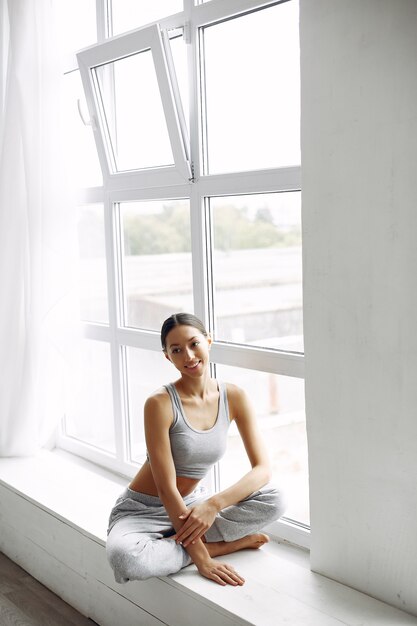 Hermosa niña sentada en un alféizar