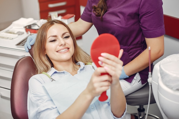 Hermosa niña sentada en el consultorio del dentista