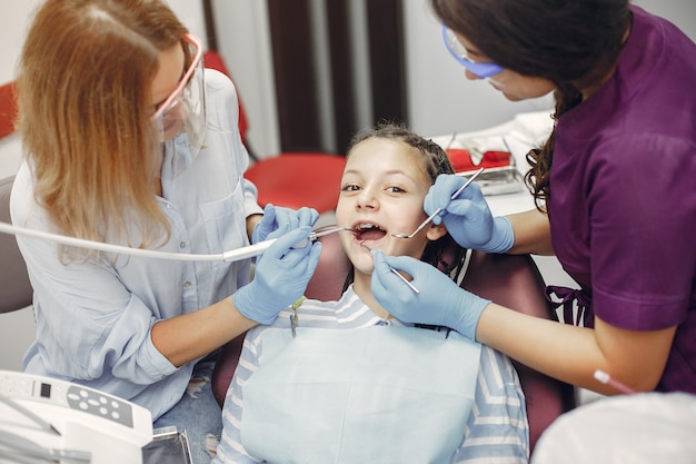 Hermosa niña sentada en el consultorio del dentista