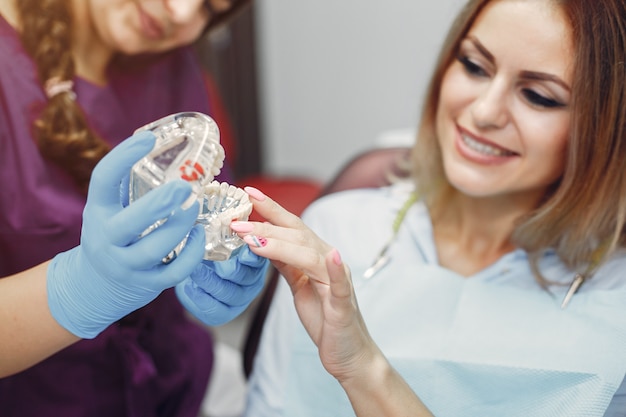 Hermosa niña sentada en el consultorio del dentista