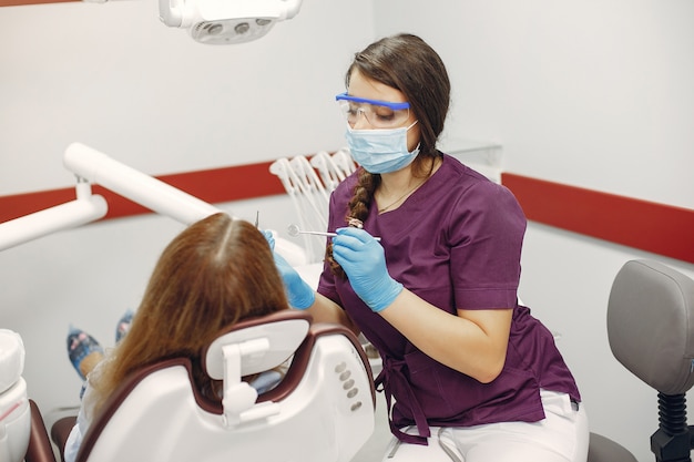 Hermosa niña sentada en el consultorio del dentista