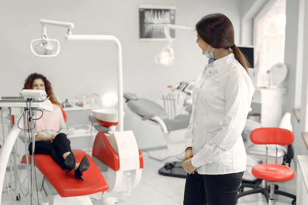 Hermosa niña sentada en el consultorio del dentista